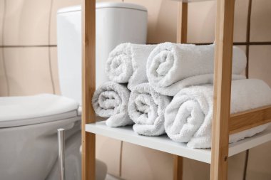 Modern banyodaki raflarda rulo havlular.