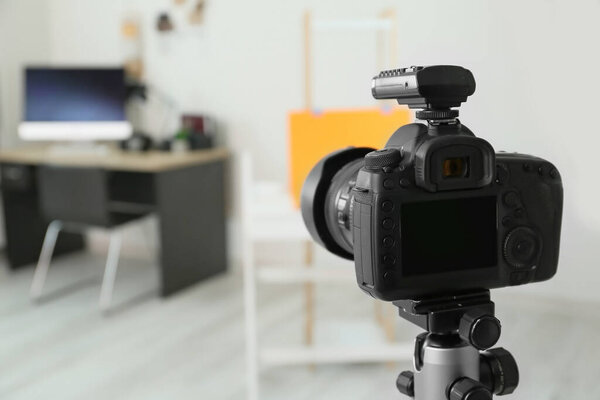 Professional camera on tripod in modern photo studio