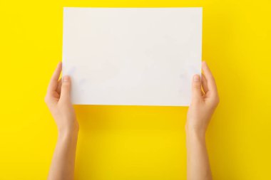 Renk arkaplanı üzerinde boş kağıdı olan kadın elleri