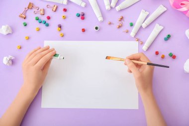 Renk arkaplanı üzerinde boş bir not defteriyle resim yapan kadın