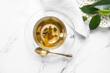 Masada bir fincan yeşil çay ve kaşık