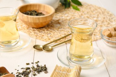 Masanın üzerinde yeşil çay bardakları olan kompozisyon