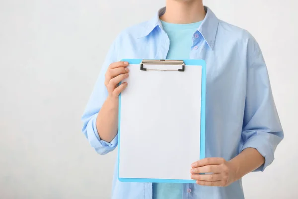 Woman with blank clipboard on white background