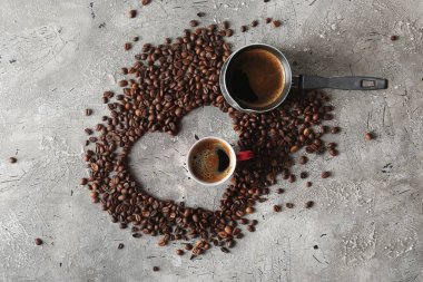 Masadaki kahve çekirdeğinden yapılmış kalp şeklinde.