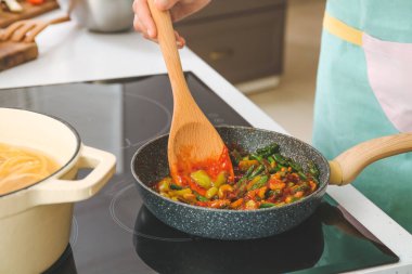 Elektrikli fırında makarna pişiren kadın.