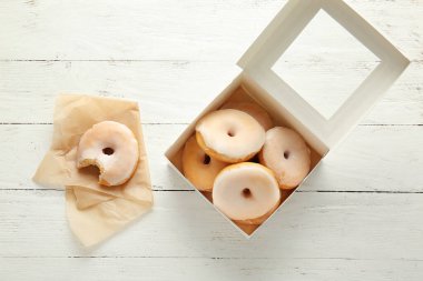 Ahşap arka planda lezzetli çöreklerle dolu bir kutu.