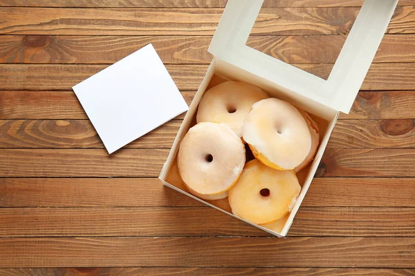 Ahşap arka planda lezzetli çöreklerle dolu bir kutu.