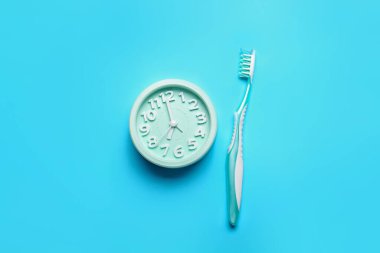 Renkli arkaplanda alarm ve diş fırçası