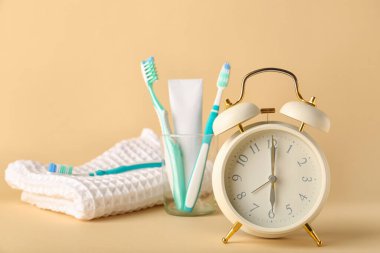 Işık arkaplanındaki alarm saati, yapıştırma ve diş fırçaları