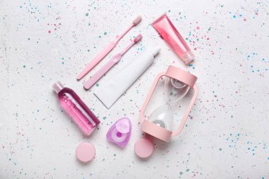 Hafif arka planda kum saati ve banyo aksesuarları.