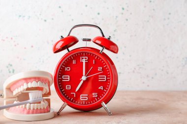 Alarm saati, masadaki çene ve diş fırçası modeli