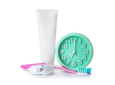 Alarm saati, yapıştırıcı ve diş fırçası beyaz arkaplanda