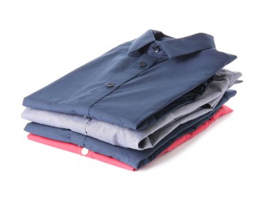 Beyaz arka planda katlanmış erkek gömlekleri yığını