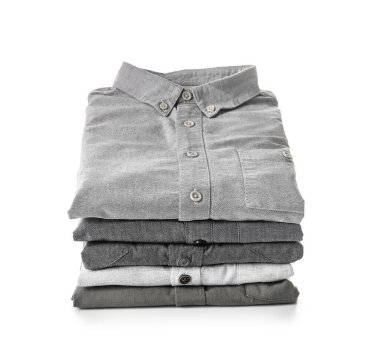 Beyaz arka planda katlanmış erkek gömlekleri yığını