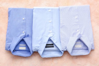 Açık arkaplanda katlanmış erkek gömlekleri