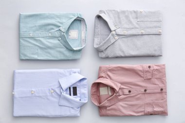 Açık arkaplanda katlanmış erkek gömlekleri