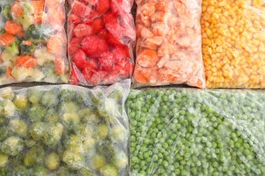 Farklı donmuş sebzelerle plastik torbalar, yakın plan.