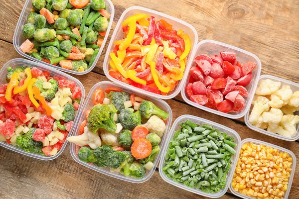 Envases Plástico Con Verduras Congeladas Sobre Fondo Madera —  Fotos de Stock