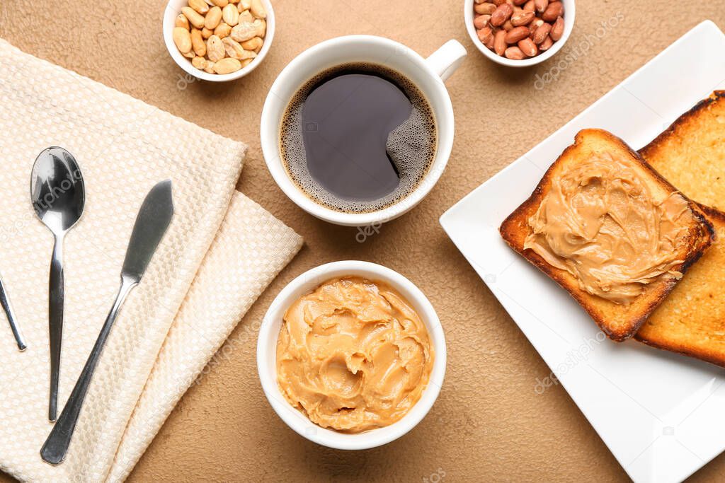 Bowl with tasty peanut butter, toasts and cup of coffee on table