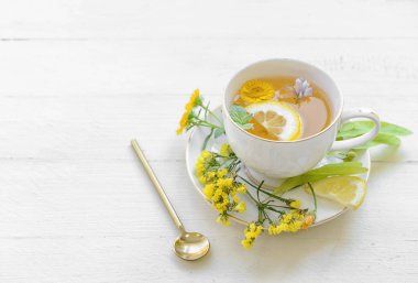 Açık arkaplanda çiçek çayı olan bir fincan.