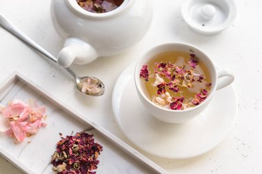 Kuru çiçekler, çaydanlık ve fincanda çiçekli çay.