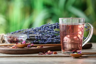 Çiçekli çay ve kuru çiçekli fincan bulanık arka planda.