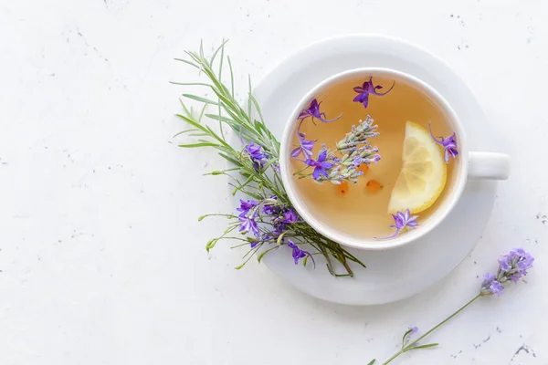 Cup with herbal tea on light background