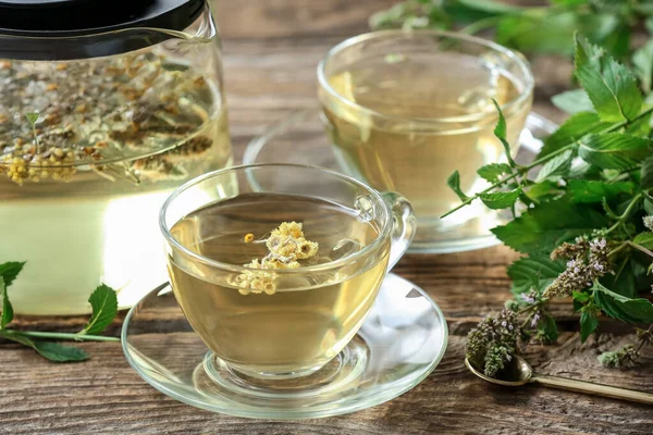 Çaydanlık ve fincanlar ahşap arka planda bitki çayı ile