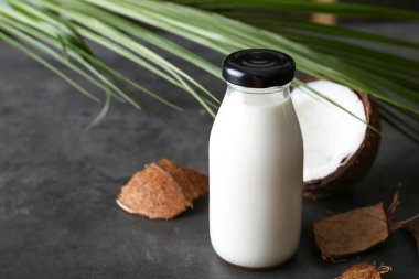 Koyu arkaplanda bir şişe hindistan cevizi sütü