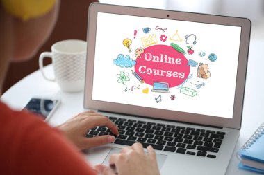 Evde online öğrenim için dizüstü bilgisayar kullanan genç bir kadın