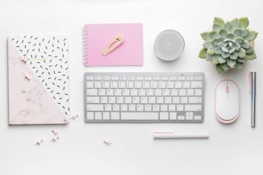 Composition with computer keyboard, mouse and stationery on white background