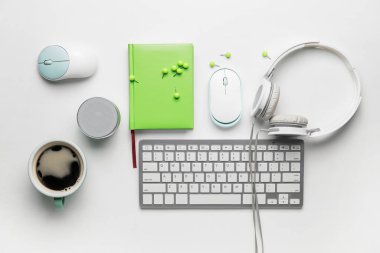 Composition with computer keyboard, headphones and mouse on white background