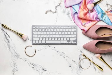 Computer keyboard, makeup brushes and accessories on light background
