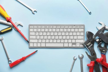 Renk arkaplan üzerinde bilgisayar klavyesi ve yapı araçları kümesi