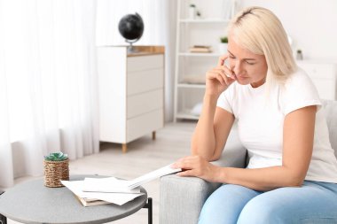 Stresli olgun kadın evde oturuyor.