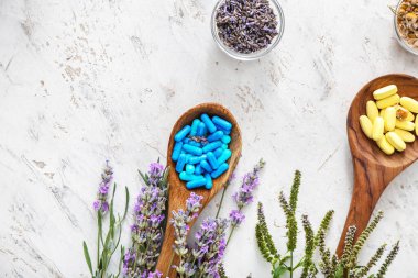 Tahta kaşıklar ve farklı bitki tabanlı haplar.