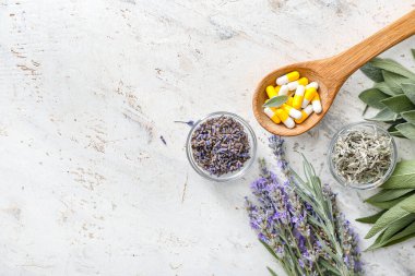 Hafif arka planda bitki bazlı haplarla ahşap kaşık