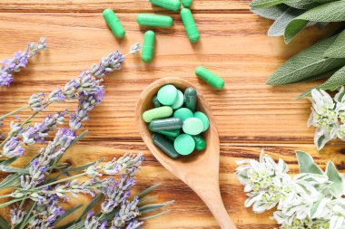 Bitki kaşıkla hapları üzerinde ahşap arka plan dayalı.