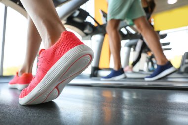 Spor salonundaki koşu bantlarında antrenman yapan gençler, yakın çekim.