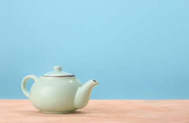 Masadaki çaydanlık renk arkaplanına karşı