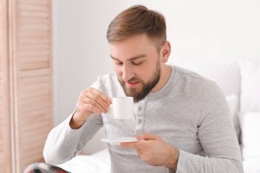 Genç adamın yatakta sıcak kahve içtiği bir sabah.