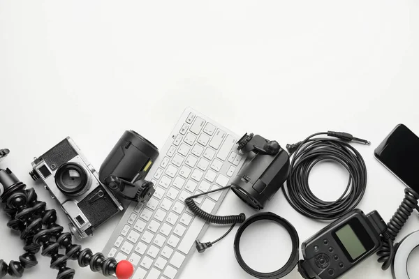 Beyaz arkaplanda bilgisayar klavyesi ve modern fotoğrafçı ekipmanı
