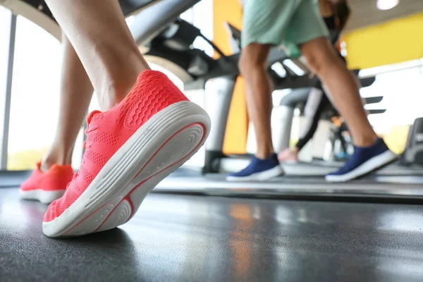 Spor salonundaki koşu bantlarında antrenman yapan gençler, yakın çekim.