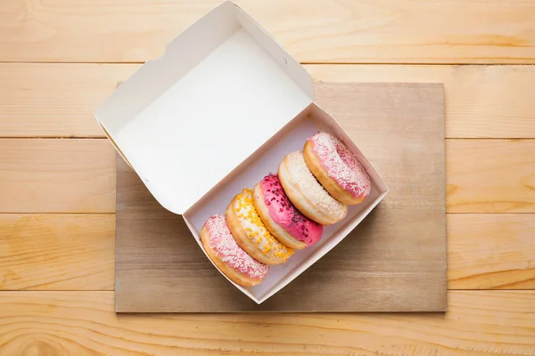 Box with sweet donuts on table