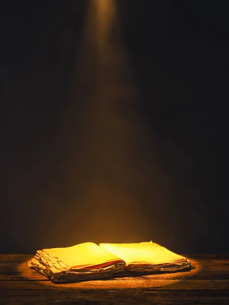 Open book on table against dark background