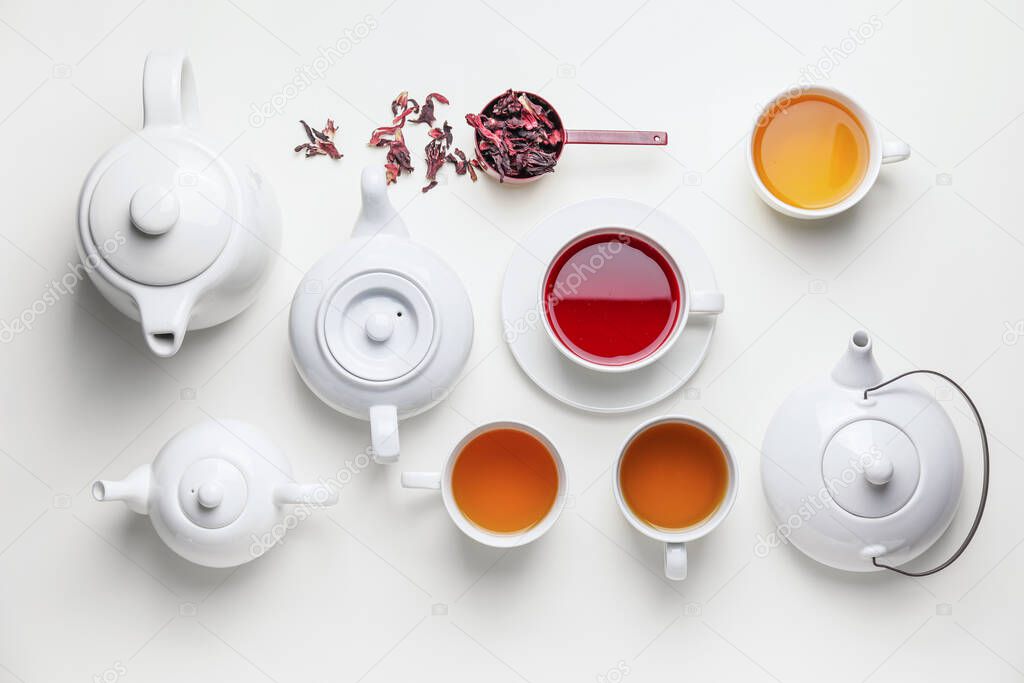 Composition with teapots and cups of tea on white background