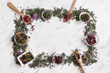 Açık arkaplanda kuru yeşil çay yapraklarından yapılmış çerçeve