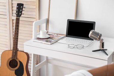 Işık duvarı yakınında modern dizüstü bilgisayarı olan rahat bir iş yeri.