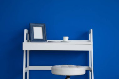 Renk duvarının yanında fotoğraf çerçevesi olan modern tablo