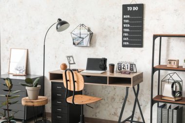 Ofisinde dizüstü bilgisayarı ve yapılacaklar listesi olan modern işyeri